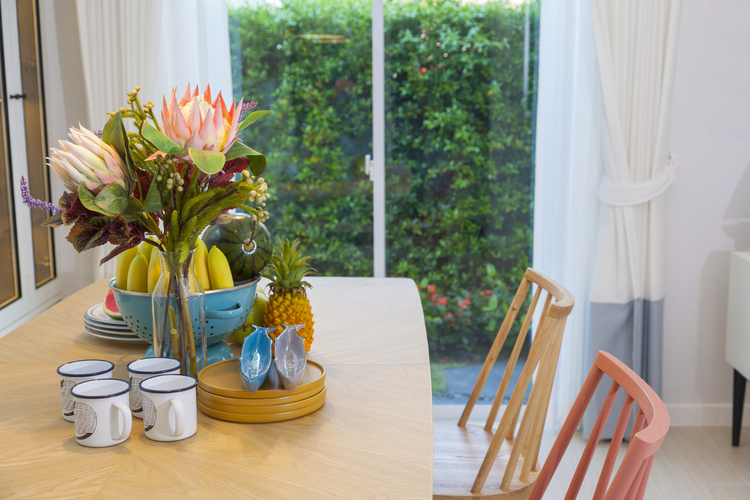 Udobna kuhinja sa svežim cvetovima na trpezarijskom stolu